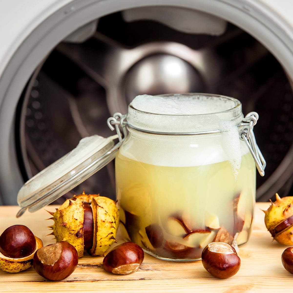 Einmachglas mit Kastanien vor Waschmaschine