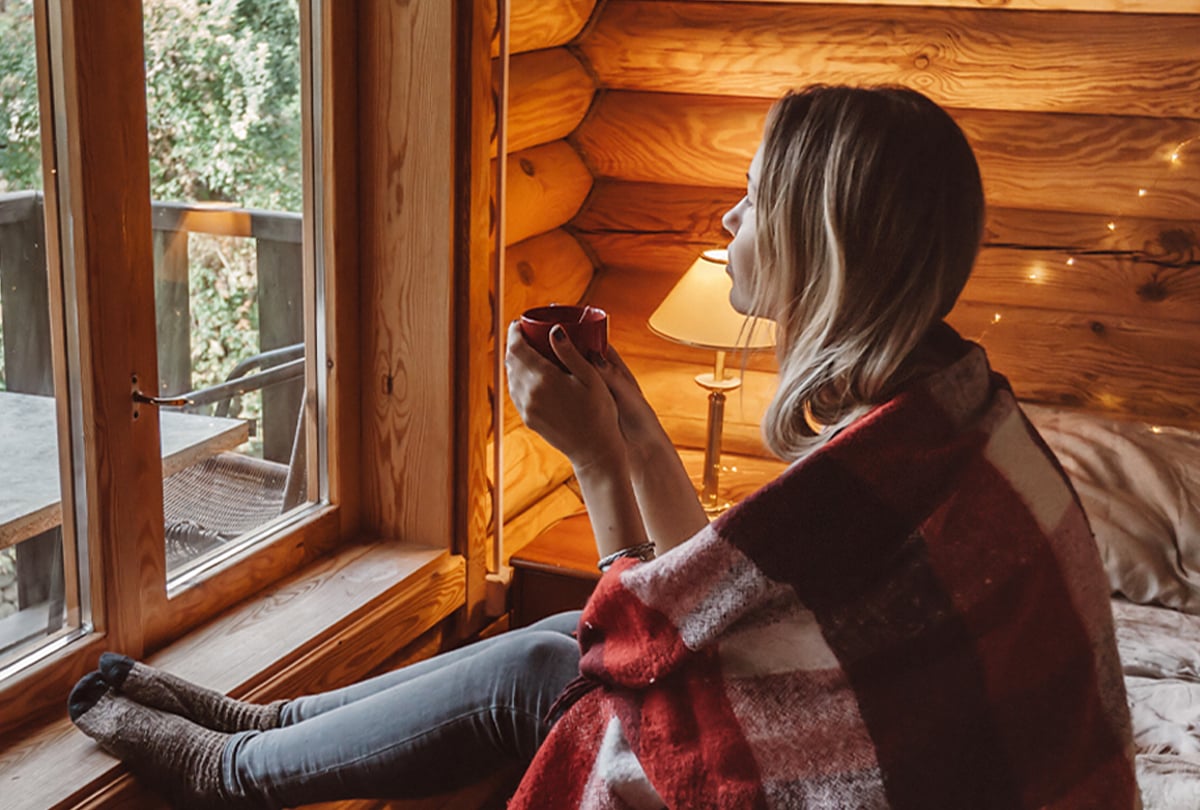 Frau mit Teetasse am Fenster